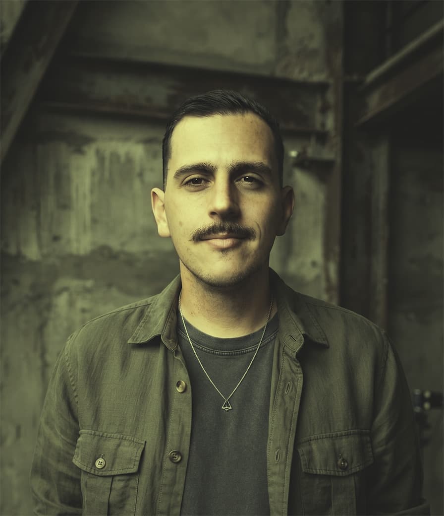 Lucas Almeida, photographed against a weathered concrete wall.